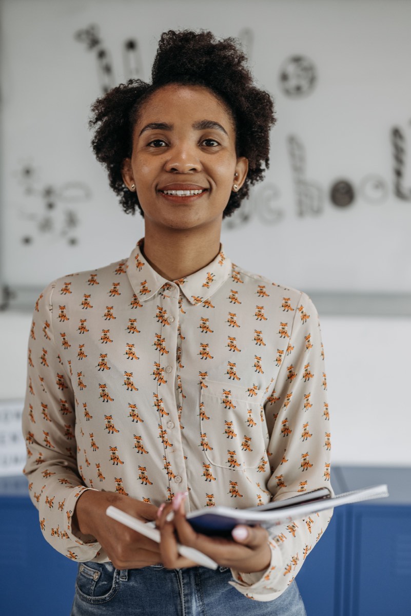 Illustrative stock photograph of an education professional holding a notebook